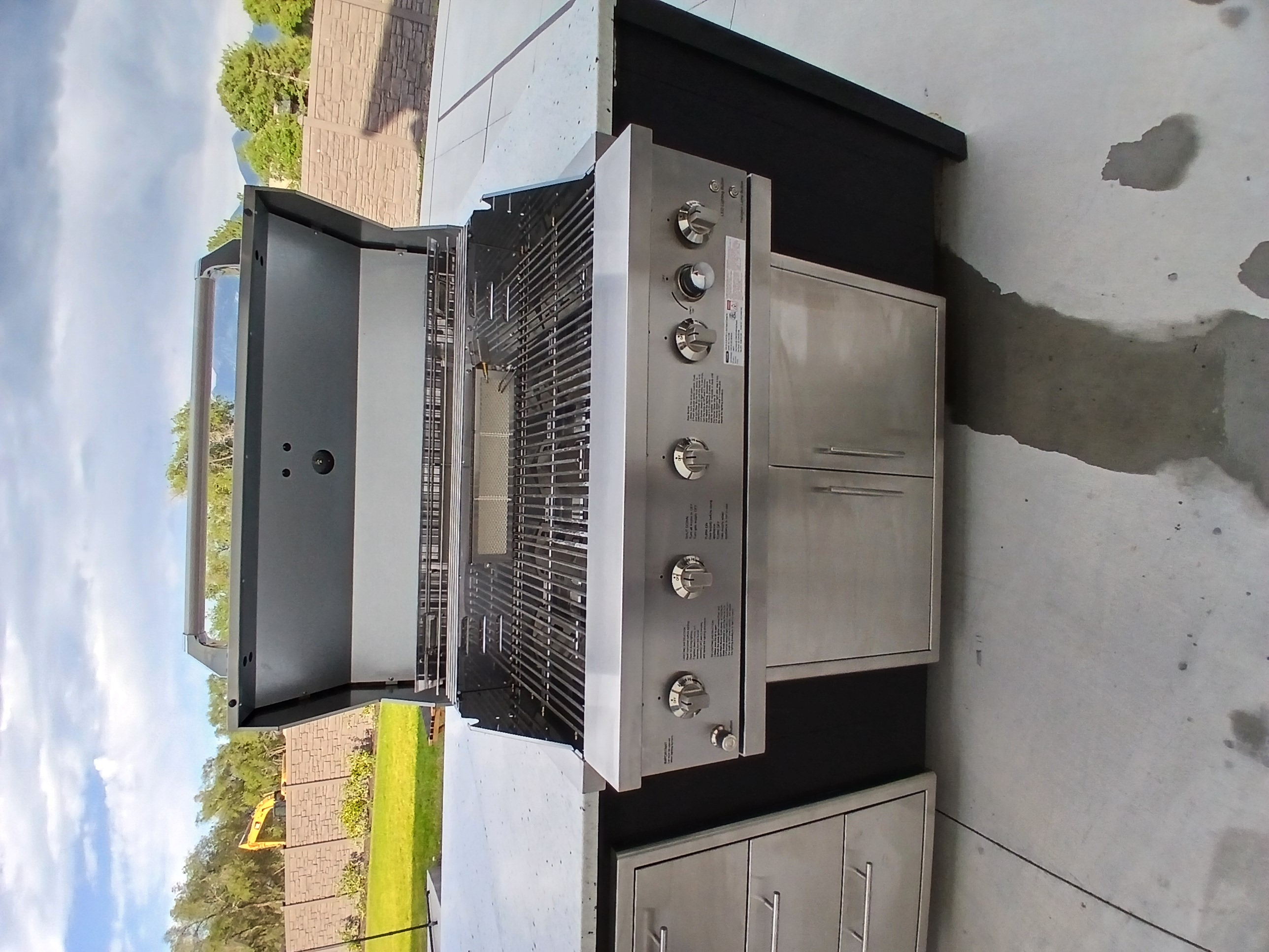Premium outdoor grill with open lid showing cooking grates